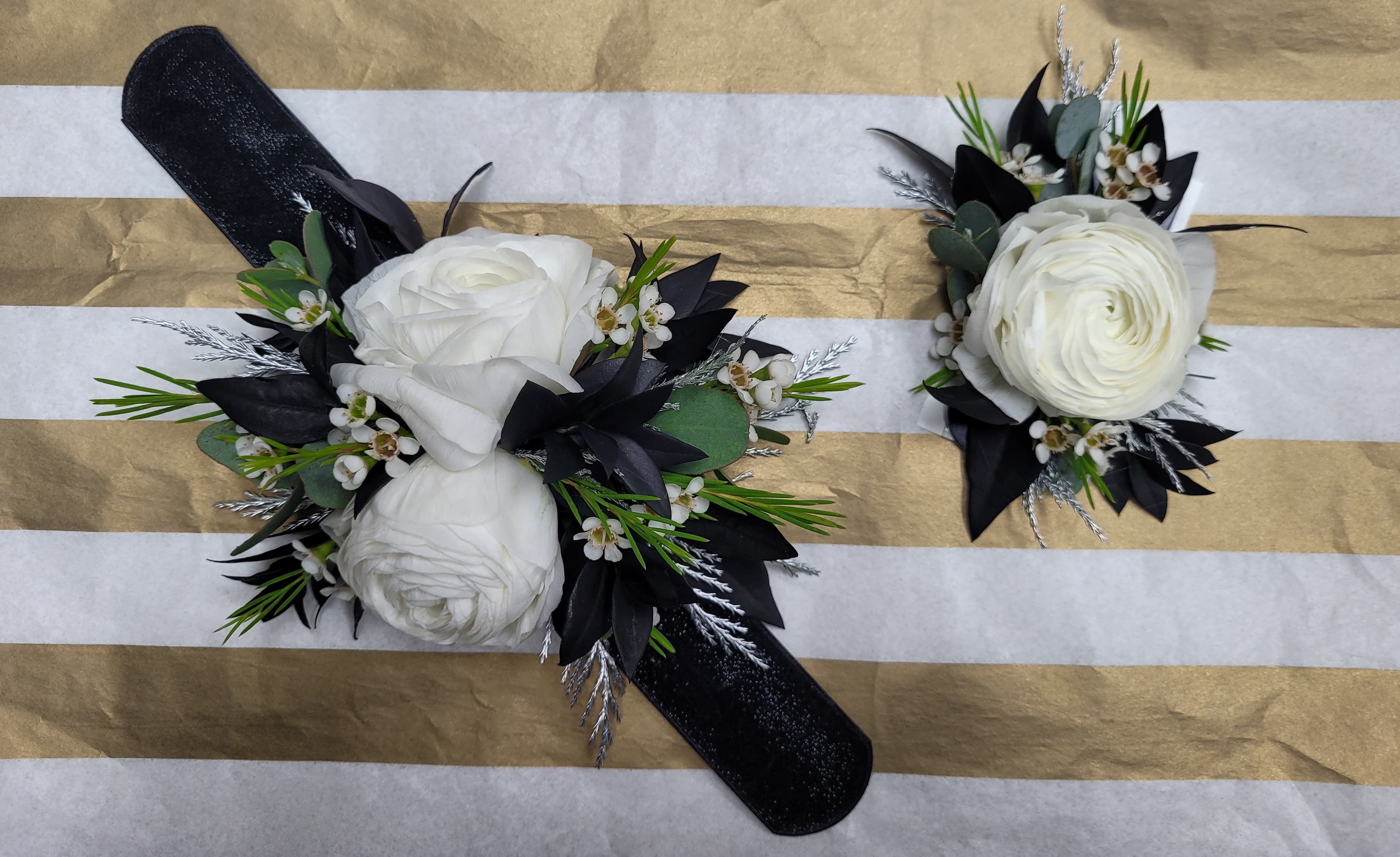 A matching corsage and boutonniere set made with white ranunculus